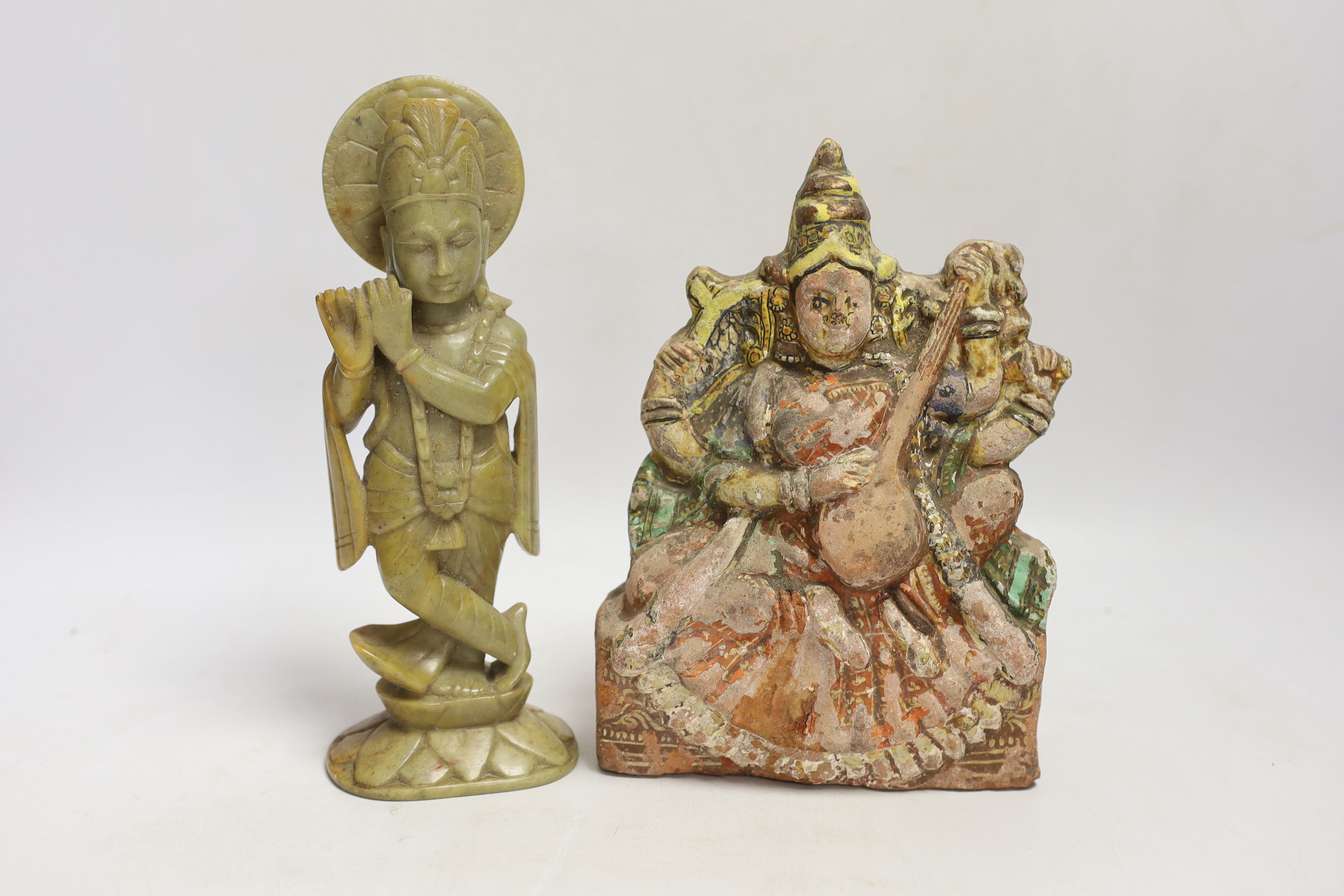 An Indian soapstone carved figure of Krishna and a terracotta figure of Saraswati, tallest 23cm